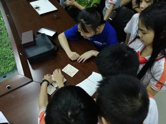 心理健康教育学生在给四年级小学生做OH牌,学生充满兴趣与好奇。.jpg